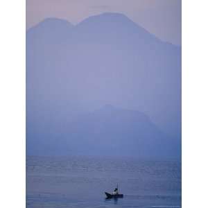  A Lone Boat Plies a Mountain Lake in Early Morning Fog 